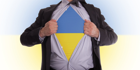 Business man rips open his shirt to show his Ukrainian flag t-shirt